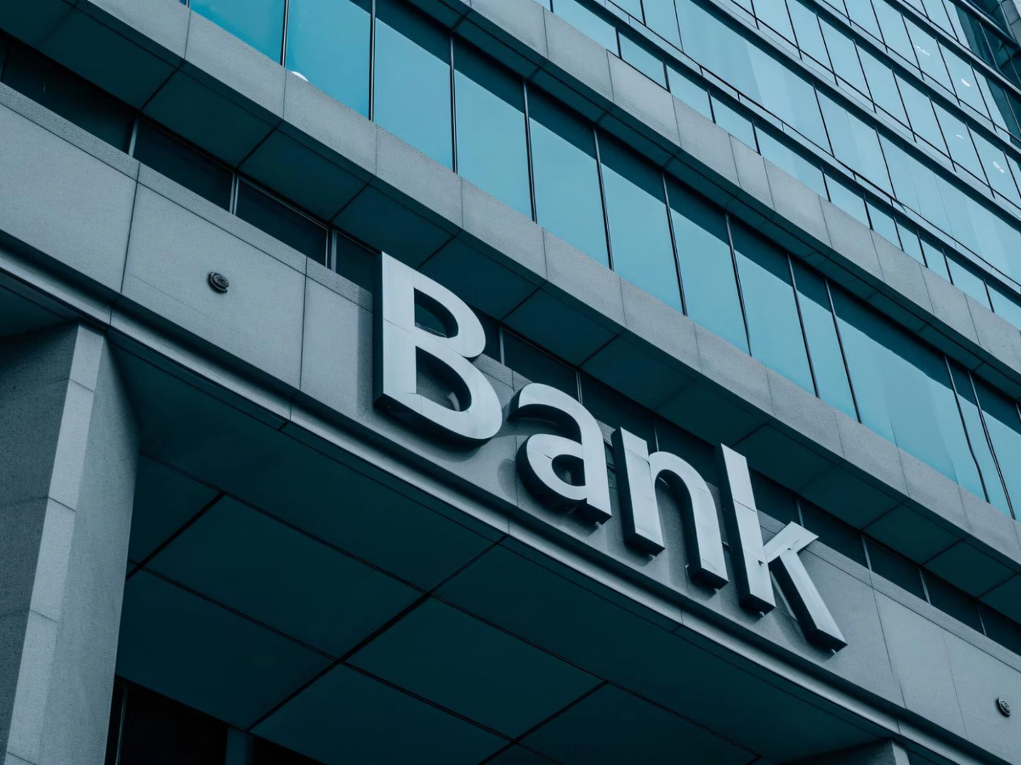 L’insegna «Bank» sulla facciata di un edificio con vetrate, vista dal basso